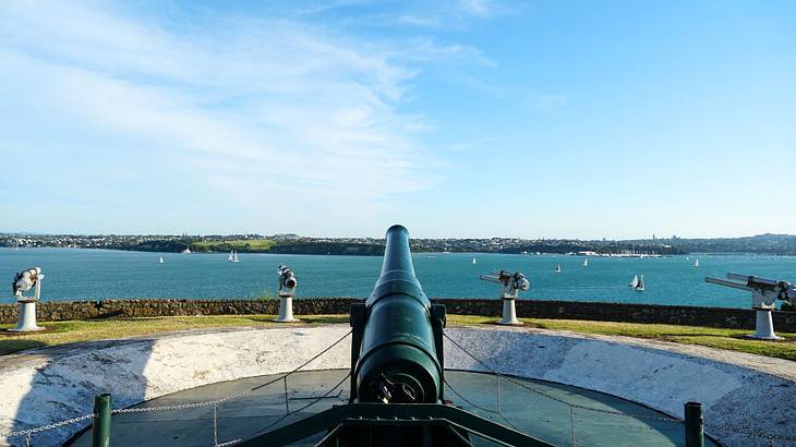 Multiple gun emplacements next to the blue ocean against the backdrop of a hazy sky