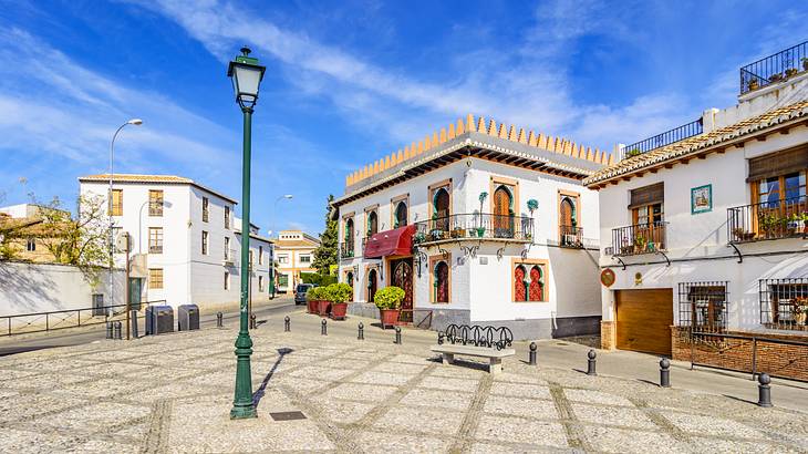 A lamppost in an open area surrounded by white houses