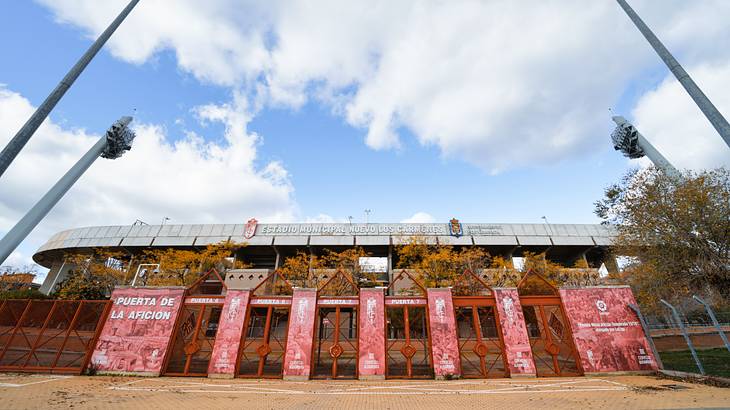 A gated stadium with advertisements and tall spotlights