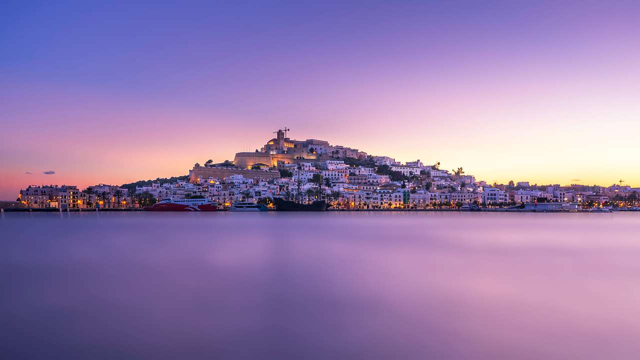 A view of a city island with many buildings during sunset