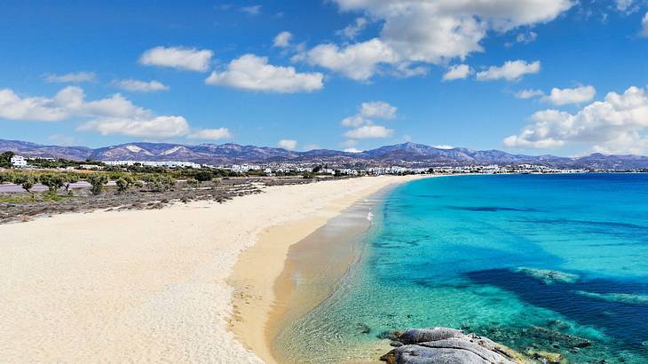 A long white sand beach next to bright blue water