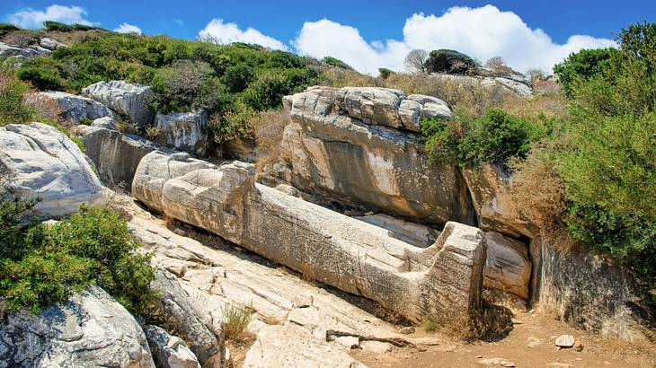 Ruins of a marble statue on a grassy hilly terrain