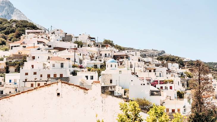 White houses on a hilly terrain under a pastel blue sky