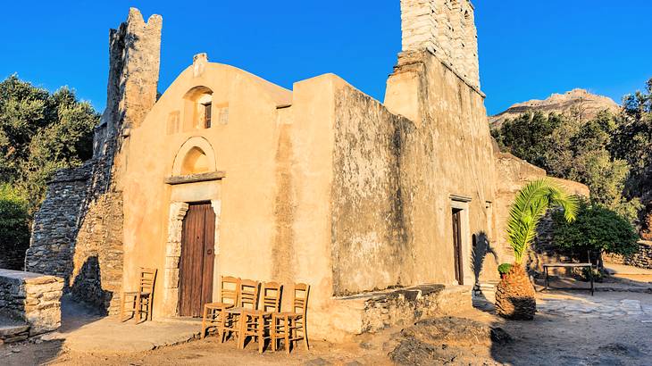 A stone church with chairs in front under a blue sky