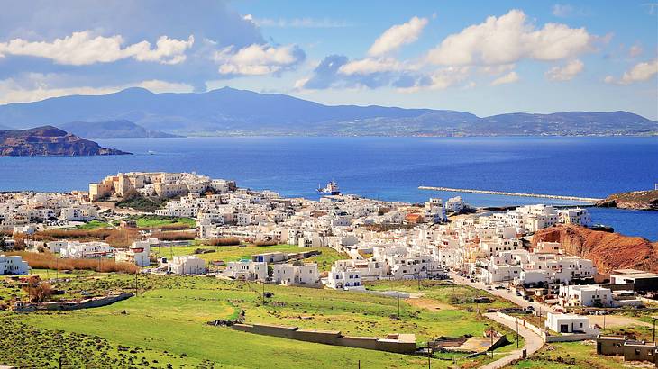 A high-angle shot of a village of white houses with the sea in the background