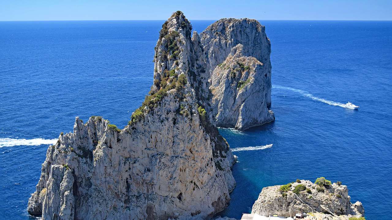 An ocean with limestone cliffs and a moving boat