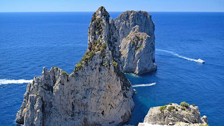 An ocean with limestone cliffs and a moving boat