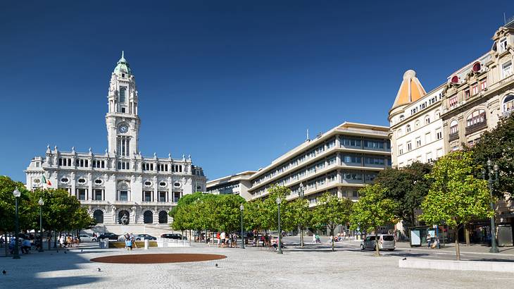 A public square with people surrounded by trees and old buildings