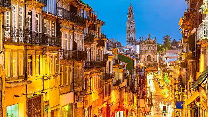 A view of a street with a cathedral illuminated at night