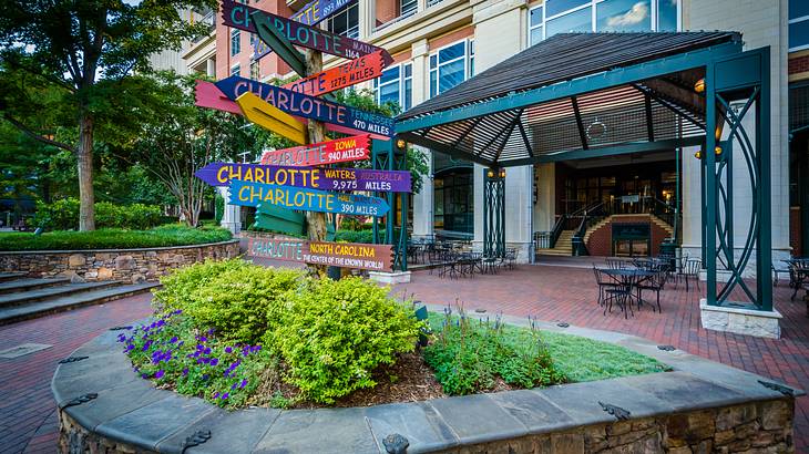 Colorful signs outside a building with greenery in the foreground