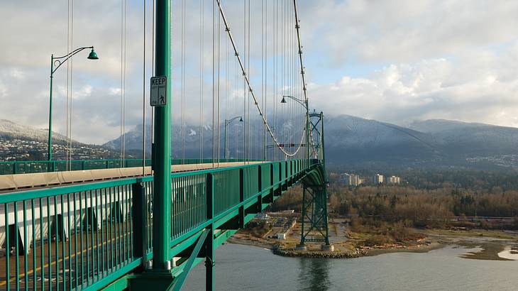 A view of mountains and a bridge over water with clouds above, Vancouver, BC, Canada
