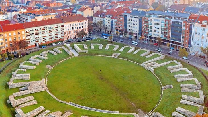 Aerial shot of ruins arranged in a circular manner near colorful buildings