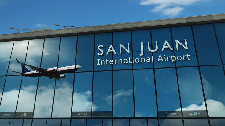 The reflection of a plane flying in the mirrored glass windows of an airport building