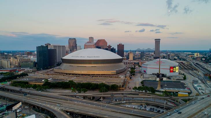 An image of two sports arenas with a highway in front and buildings behind them