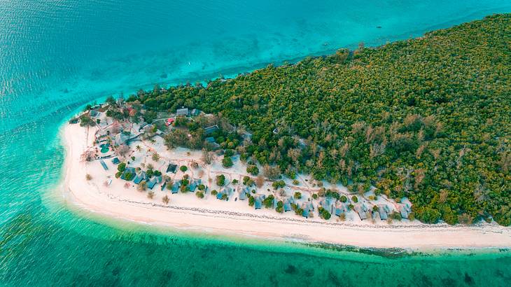 Aerial view of Bawe Island with lush green trees and sand surrounded by blue water