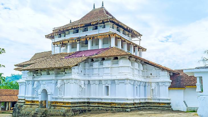 A white building decorated with statues of elephants, pillars, and dragon arches