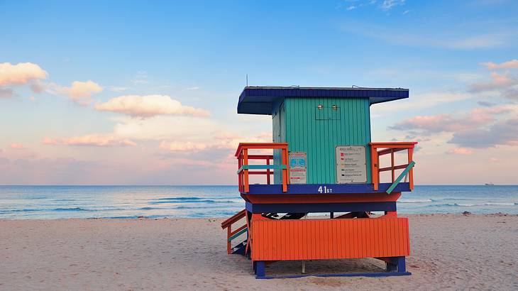 Green and orange lifeguard house on a white and sandy quiet beach