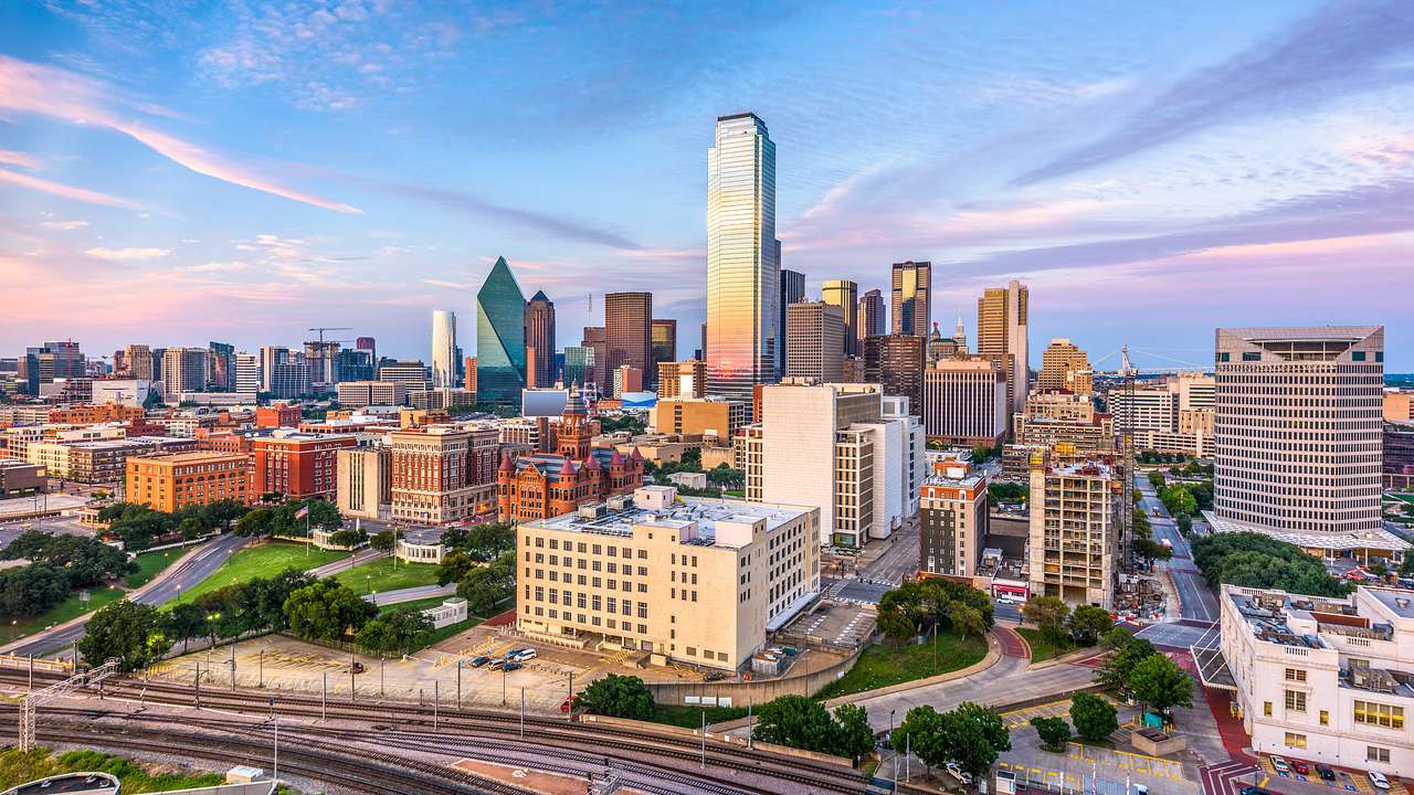 The Dallas city skyline under a blue and purple sky
