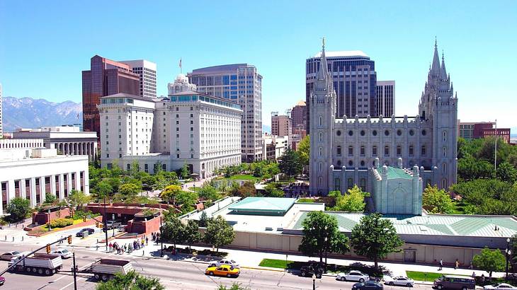 A view of buildings and a religious building with trees and a road in the foreground