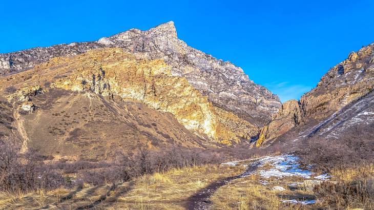 A mountain with some snow on it under a clear blue sky