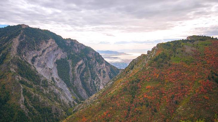 Two mountains covered in greenery under a cloudy sky