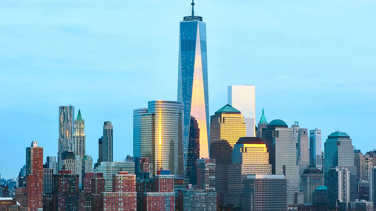 One World Trade Center surrounded by other skyscrapers with water in front