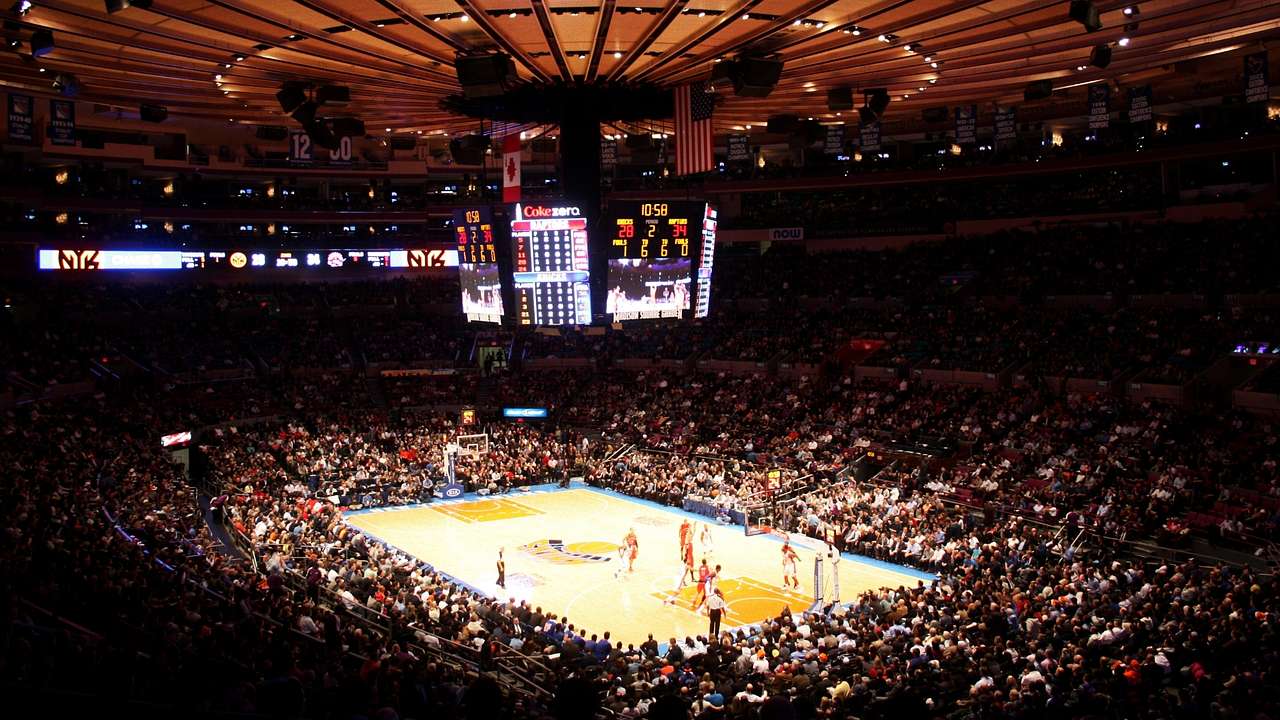 A basketball game played in a stadium with fans surrounding the court