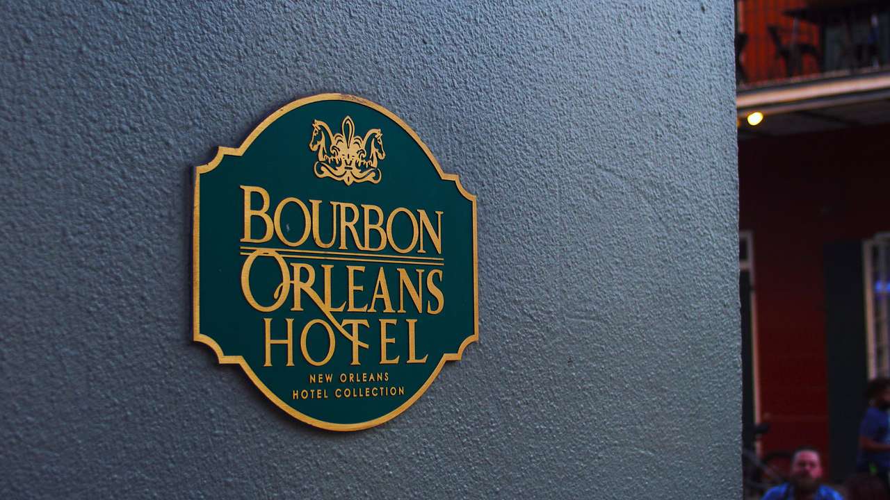 A black painted wall with a signboard that reads "Bourbon Orleans Hotel"