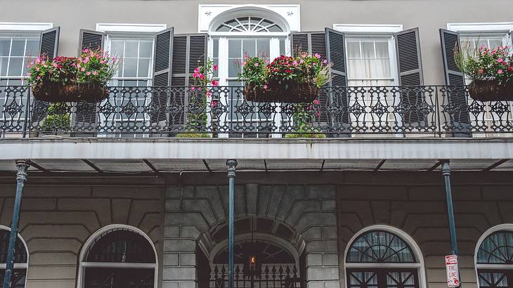 A one-floor house with flower pots hanging from the first-floor fence