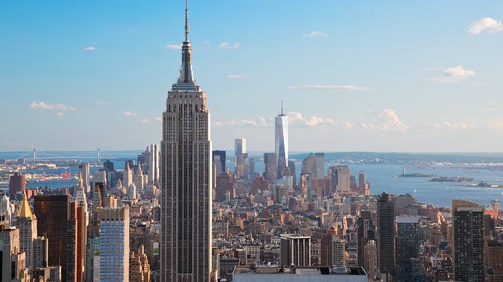 A tall tower next to a city skyline with water in the distance