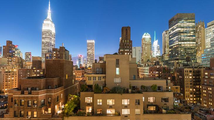 Illuminated city buildings in the evening as seen from another building