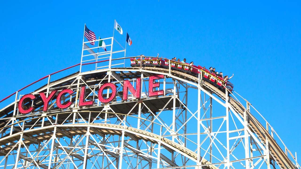 A roller coaster with a sign that says "Cyclone" on a clear day