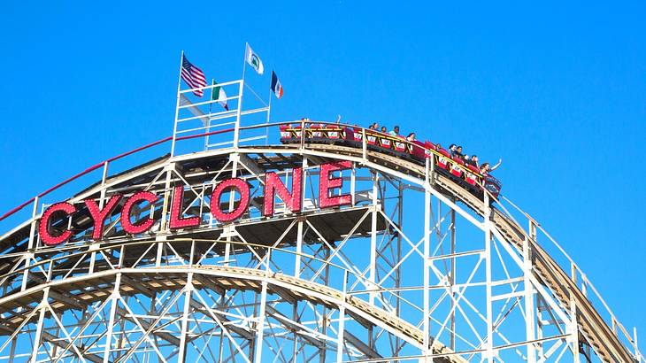 A roller coaster with a sign that says "Cyclone" on a clear day