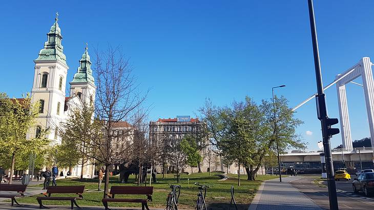 A park with benches and bikes near a church