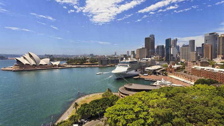 A harbor with a large vessel near tall skyscrapers and buildings