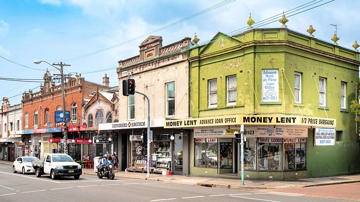 Old colorful adjacent buildings near a road with vehicles