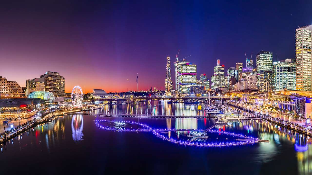 Glowing lights from city skyscrapers and structures near a body of water