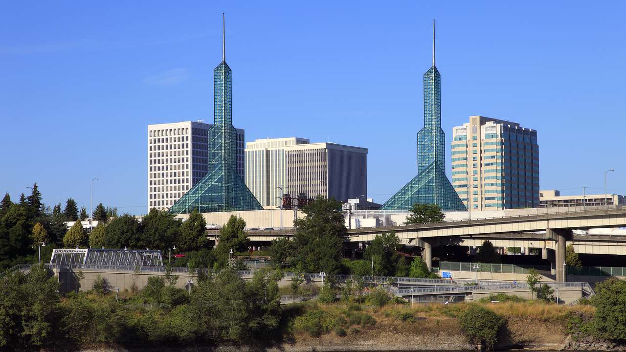 Skyscrapers and two identical towers near a body of water