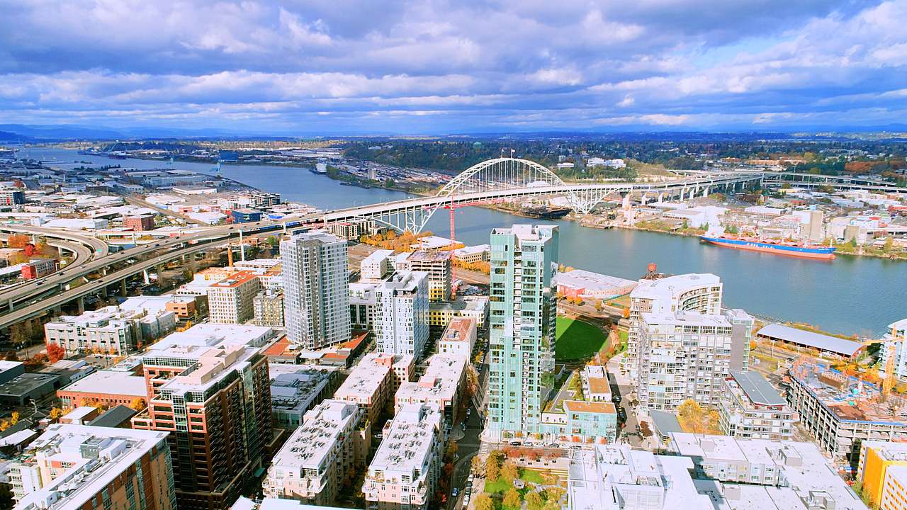 An aerial shot of a city near a bridge over a river
