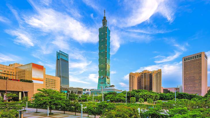 A tall skyscraper near buildings and trees