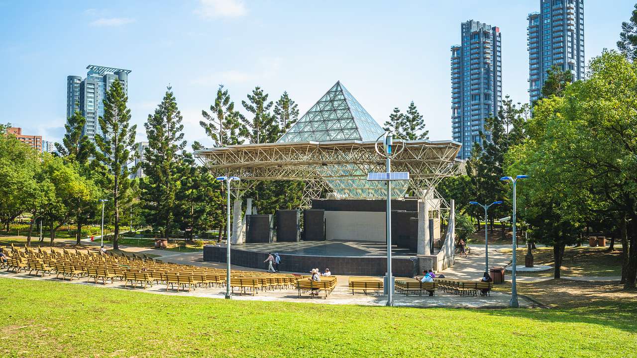 A stage in a park with buildings in the background