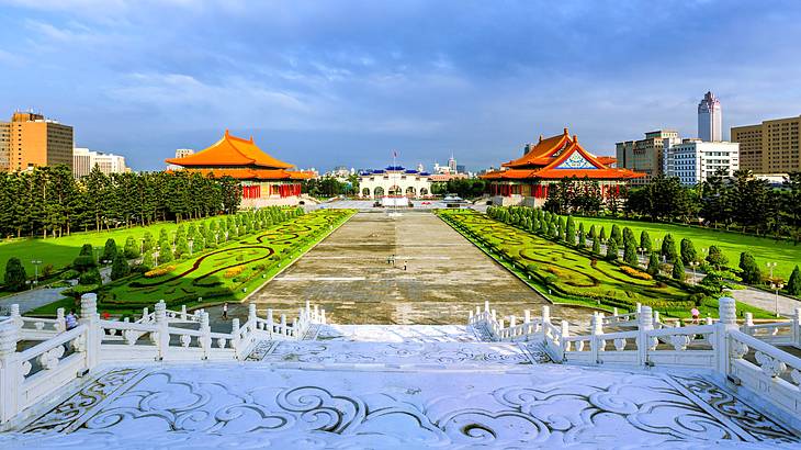 White stairs leading to a garden with a walkway and temples