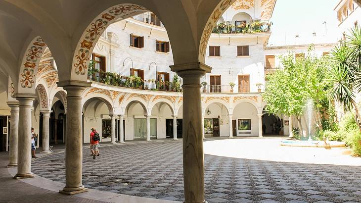 A square with white arches with painted designs on them surrounding it