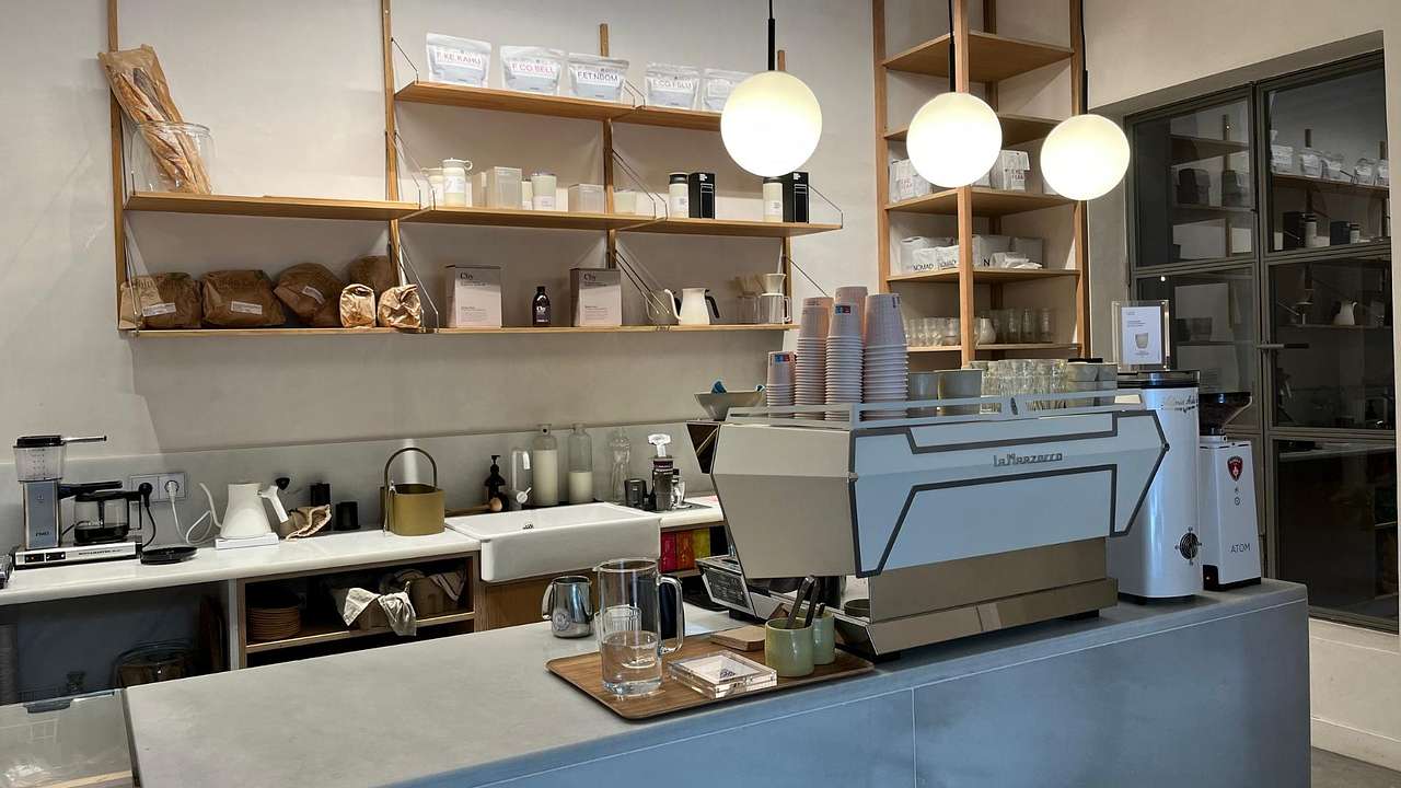 The interior of a modern cafe with a coffee machine and fresh bread on a shelf