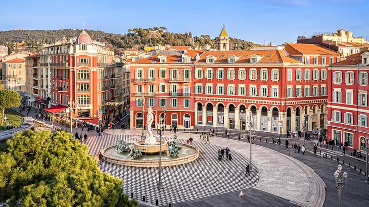 Aerial view of a large square in Nice, France full of red buildings and people