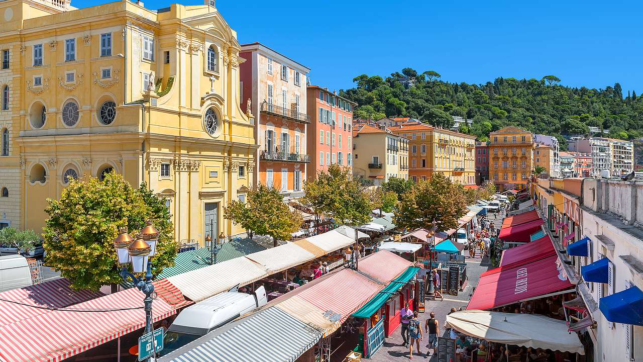 Aerial view of a market below surrounded by brightly-colored buildings, Nice, France