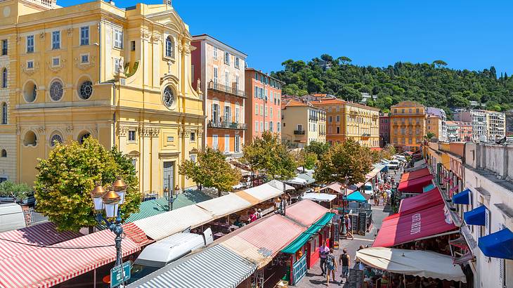 Aerial view of a market below surrounded by brightly-colored buildings, Nice, France