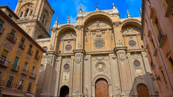 A Renaissance cathedral building with columns and three arched doors