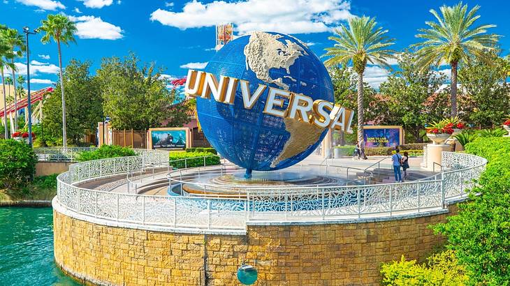 A globe structure with "Universal" on it surrounded by water and greenery