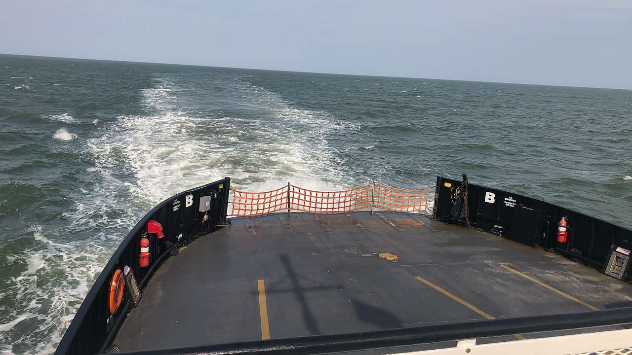 The back of a ferry boat moving along on water